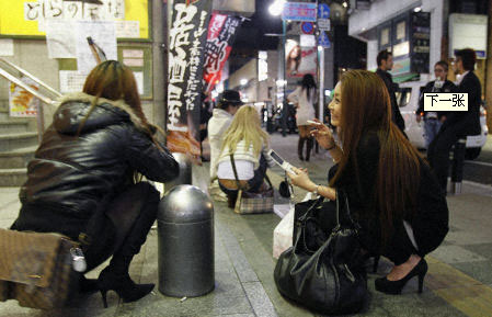 2011年4月7日晚，日本东北部海域发生里氏7.4级地震，民众采取各种方式避灾。图为仙台民众在街头蹲下躲避。